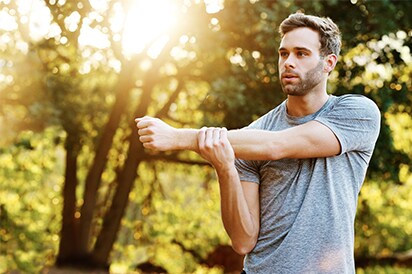 man stretching before going for a run outside